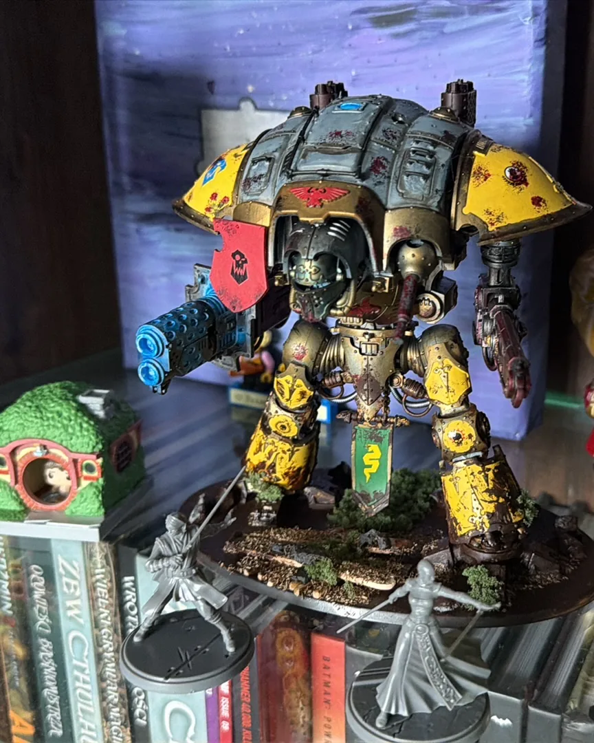 Pomalowana figurka z Warhammera na półce z książkami i innymi figurkami